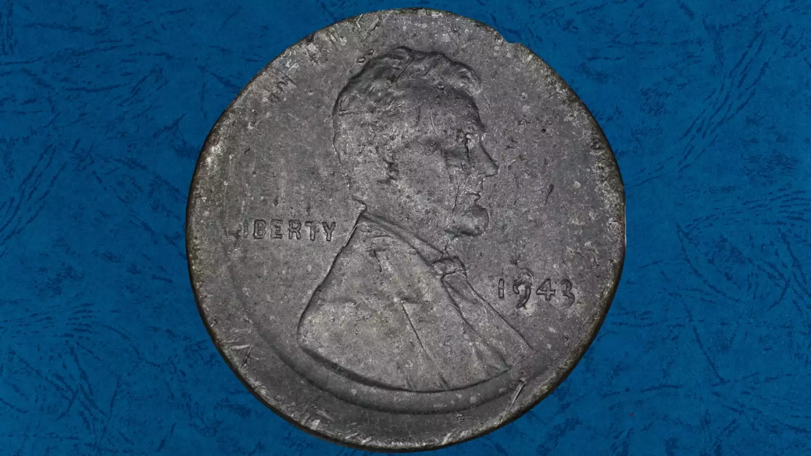 1943 steel wheat penny off-center strike error showing design shifted from center with blank planchet visible at edge